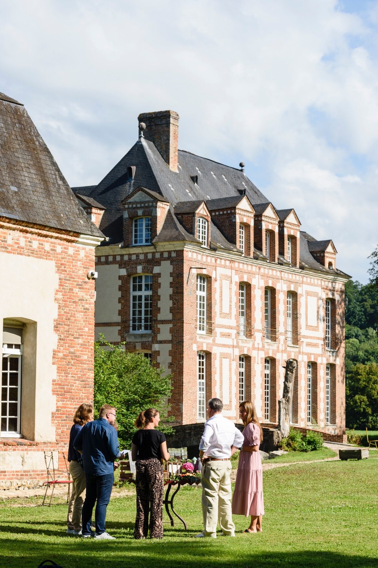 Groupe devant un grand manoir en brique